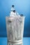 Trash can with wasted plastic bottles, blue background