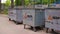 Trash cans on site for garbage in courtyard. Metal containers.