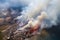 Trash fires rage in aerial view of a sprawling landfill site