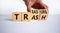 Trash to treasure symbol. Businessman turns cubes and changes the word trash to treasure. Beautiful white table, white background