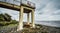 Trashed fridge into the lifeless sea, Caspian sea under blue sky in early September, snag on the beach, Rusty bridge on the beach