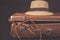 Travel and adventure concept. Vintage brown suitcase with fedora hat and bullwhip on dark