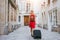 Travel background, woman tourist walking with suitcase on the street in european city, tourism