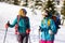 travel with a backpack in the woods in winter in the snow. two girls walk through the forest and laugh. conversation between two