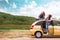 Travel banner. Caucasian mother and her teen daughter dreamy posing by a yellow car. The concept of freedom and travel