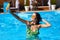 Travel blogger woman taking selfie photo with action camera in a swimming pool. Lifestyle vlogger films vlog from luxury