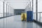 Travel, booking and vacation concept with blue and yellow suitcases on concrete floor in empty airport corridor with mat glass