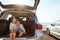 Travel buddies. two little girls sitting in the trunk of a car.