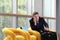 Travel business man talking on the phone, sitting with luggage, waiting room, yellow chair