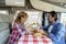 Travel on camper van lifestyle. Alternative vehicle vacation living vanlife offgrid. People having lunch. Man and woman couple