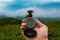 Travel, camping, orienteering and navigation concept - black magnetic compass close-up in a man s hand, blurred landscape