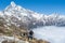 Travel climber standing near clouds at the mountains