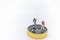 Travel Concept. Close up of two traveler miniature figure with backpack  standing on compass on white background and copy space