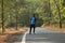 Travel concept man carrying backpack walking on the road passes through beautiful forests.