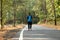 Travel concept man carrying backpack walking on the road passes through beautiful forests.