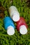 travel cosmetics in small bottles: shower gel, shampoo and conditioner. cosmetics in red, blue and white colours in gras