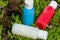 travel cosmetics in small bottles: shower gel, shampoo and conditioner. cosmetics in red, blue and white colours in gras