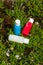 travel cosmetics in small bottles: shower gel, shampoo and conditioner. cosmetics in red, blue and white colours in gras