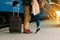 Travel Couple of young lovers kissing outdoors with closeup on legs and shoes. Train station on background. Warm evening