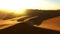 Travel, desert and silhouette of man at sunset with drone for destination, freedom or summer trip. Footprints, adventure