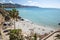 Travel destination, view on sandy beach, blue sea and mountains from Balcon de Europa in small Andalusian town Nerja with white