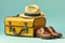 travel essentials suitcase with straw hat, sunglasses, passport, and slippers on blue background