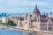 Travel and european tourism concept. Parliament and riverside in Budapest Hungary with sightseeing ships during summer day with bl