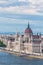 Travel and european tourism concept. Parliament and riverside in Budapest Hungary during summer sunny day with blue sky and clouds