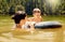 Travel, float and mother with her child in lake swimming while on a summer vacation or adventure. Happy, tubing and