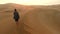 Travel, freedom and desert man walking in dunes of Namibia for adventure, sunset and holiday drone. Peace, explore and