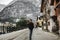 Travel girl with a backpack enjoying the magnificent snowy mountain in village of Hallstatt with Lake Hallstadt in winter. Travel