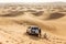 Travel guide men with four wheel drive car on the great desert at Dubai