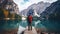 Travel hiker taking photo of Lake Braies (Lago di Braies) in Dolomites Mountains, Italy. Hiking travel and adventure