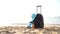 Travel holiday vacation suitcase with cream, straw hat and diving mask on the beautiful beach. Advertisement on travel