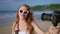 Travel influencer films with pro camera on beach. Content creator engages audience, shares tips recording vlog for