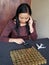 travel investment, brunette woman counting her savings with a figure of a white airplane and coins on the gray table