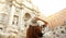 Travel in Italy. Back view of attractive young woman looks Trevi fountain famous landmark in Rome. Happy girl enjoy Italian
