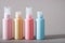 Travel kit. Set of four plastic bottles for cosmetic products. Gray background