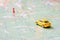 Travel and leisure concept. A yellow toy car travels along the route to the destination point indicated by a red pushpin.The car