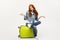 Travel and Lifestyle Concept - Portrait young red hair woman sitting on a bag with boring facial expression, isolated on