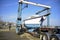 Travel lift unloading large sailboat from flat bed truck