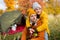 Travel, love and autumn concept - happy couple in love posing near green tent in autumn forest