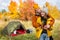 Travel, love and autumn concept - portrait of couple in love posing near green tent in autumn forest