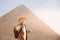Travel man in hat stand background Egyptian pyramid sunset Giza Cairo, Egypt
