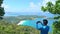 Travel man stands on the high mountain at Phahindum view point popular landmark in Phuket Thailand and shoots video and photo with