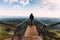 Travel man tourist alone on the edge viewing platform or observation point made from metal over amazing epic valley mountains