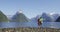Travel in nature - happy free tourists with wanderlust enjoying Milford Sound