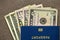 Travel passport and money, American dollars banknotes bills on copy space background, top view. Traveling and finance problems