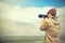 Travel photographer journalist holding a dslr camera in mountain background