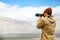 Travel photographer journalist holding a dslr camera in mountain background